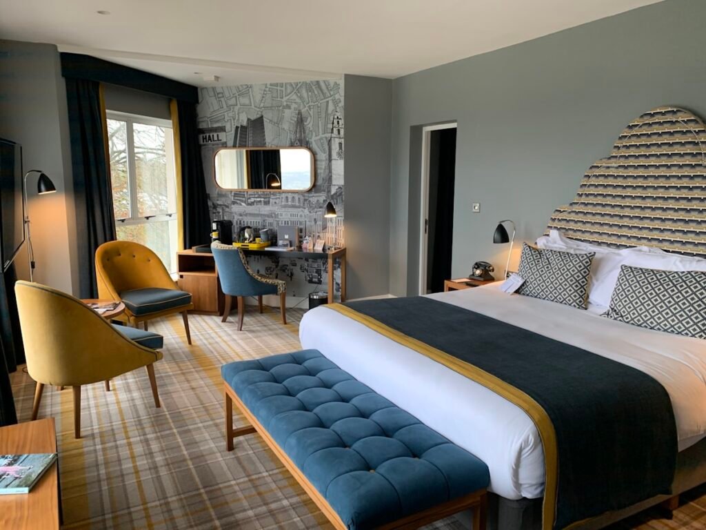 Luxury suite bedroom with upholstered headboard and soft ambient lighting at Marble Sky Suite